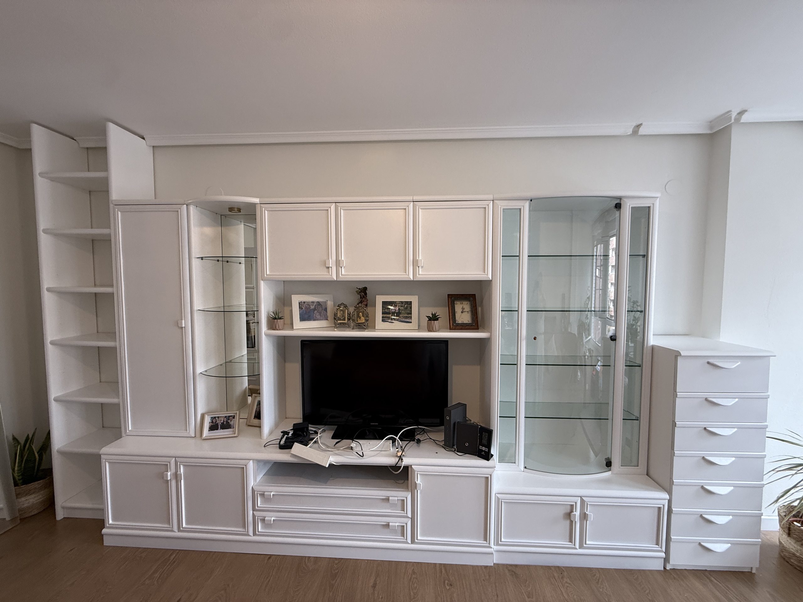Mueble de salón blanco con vitrinas y estanterías, trabajo de Pinturas Campete