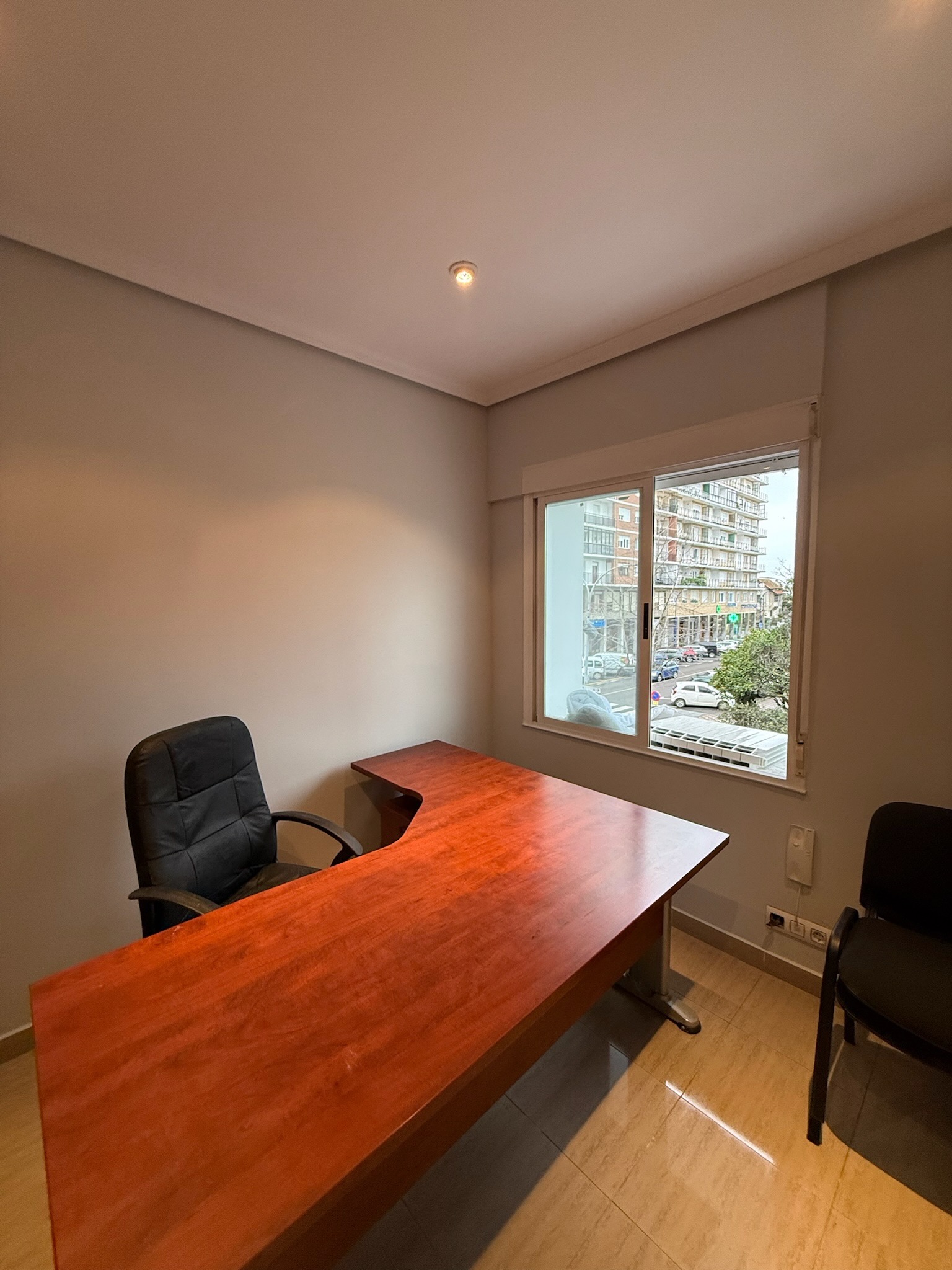 Despacho con paredes claras y muebles de madera